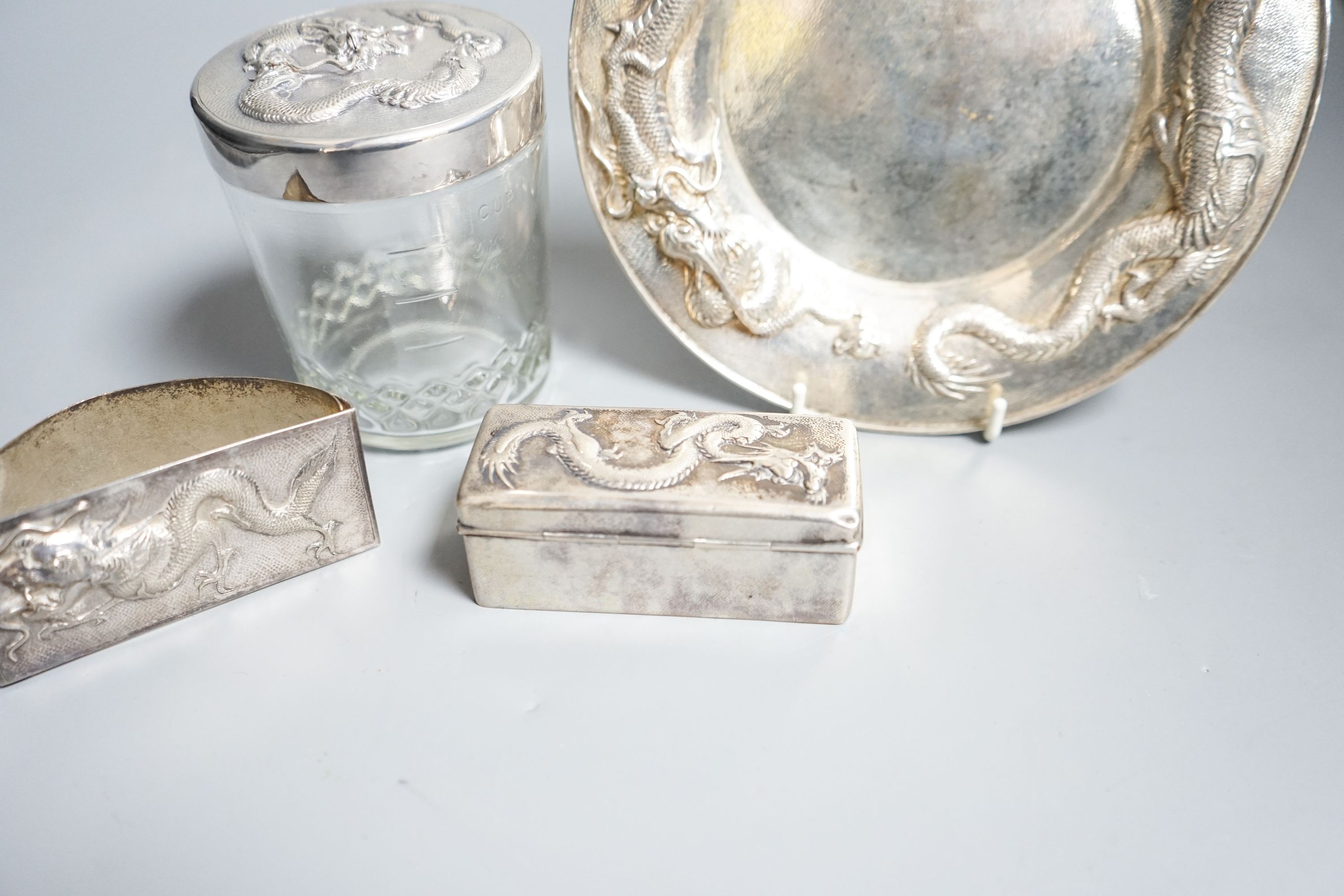 A Chinese white metal dish by Wang Hing, 18.4cm and a similar rectangular box, a white metal mounted jar by Tack Hing and an unmarked blotter.